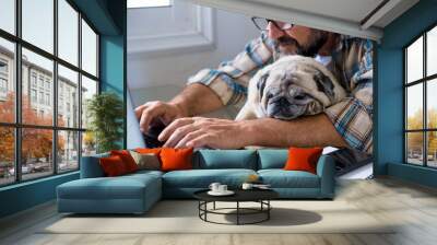 Funny couple man and dog work together at home with laptop online job computer in friendship and happiness - concept of smart work digital lifestyle for modern people Wall mural