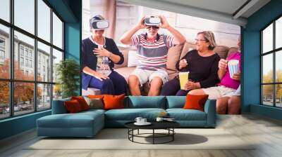 Group of aged old friends have fun at home with vr goggled headset and pop corn - party celebrating time with laughs and friendship for caucasian mature people Wall mural