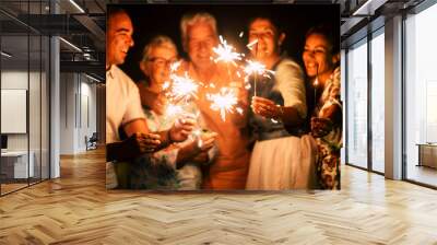 group of people have fun celebrating together new year eve or birthday with sparkles light and fireworks in friendship outdoor at evening time - family and friends different ages celebrate friendly Wall mural