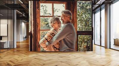 Happiness and togetherness concept lifestyle with senior retired caucasian couple enjoy love and relationship at home hugging and laughing. Man and woman elderly life concept indoor Wall mural