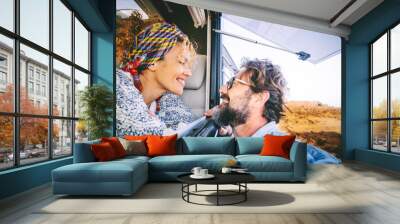 Happy adult tourist and traveler smile and have fun together inside and outside the camper car. Cheerful happy people enjoying travel and vacation. Mature couple in love and friendship portrait Wall mural