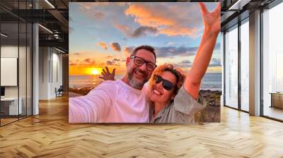 Happy adult traveler enjoy sunset in tropical destination beach together having fun and taking selfie picture to share on social media. Traveler influencer lifestyle. People summer holiday vacation Wall mural