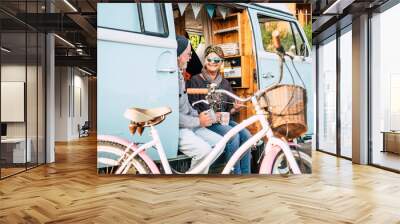 Happy and cheerful senior people couple enjoy the travel and retired lifestyle taking a coffee together inside an old van with a bike outdoor for healthy lifestyle - no limit age and traveler Wall mural