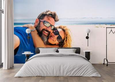 happy and healthy couple of people enjoying their life and their vacations outdoors at the beach together taking a selfie with the sea or ocean in  background - two happy people taking a picture  Wall mural