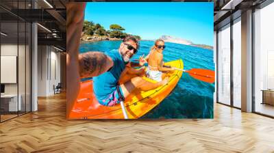 Happy couple of tourist taking selfie inside a kayak canoe in summer holiday travel vacation smiling and having fun at the camera. Cheerful man and woman on a boat. Blue clean beautiful sea ocean Wall mural