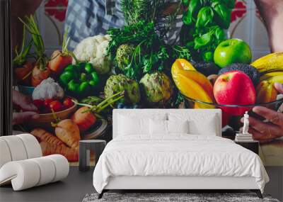 Man with composition of fruits and vegetables hug healthy lifestyle food. Diet and weight loss people concept. Chef ready to work and prepare vitamin fresh tasty salads with bio products local market Wall mural