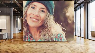 Middle age beautiful woman portrait with hipster style and warm woolen hat in outdoor with defocused bokeh nature background - cheerful happy people female caucasian looking at camera Wall mural