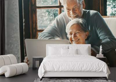 Old senior couple at home use laptop for video call to friends or parents. Distance and remote communication with laptop and internet technology. Elderly people enjoy day and lifestyle using notebook Wall mural