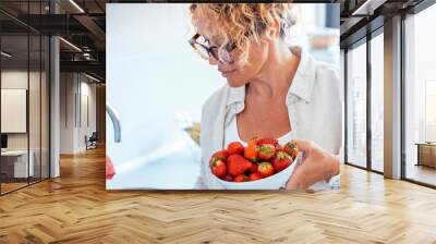 One midage woman at home with fresh bowl of red strawberries seasonal fruit. Concept of weight loss and calorie deficit count. Eating natural dieting healthy people female lifestyle. Strawberry fruits Wall mural