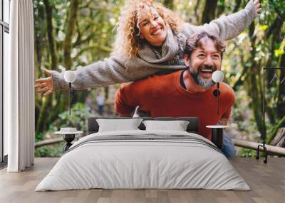 overjoyed adult couple have fun together at outdoor park in leisure activity. man carrying woman in  Wall mural