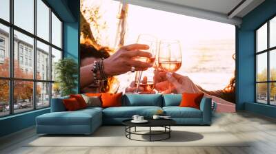 people drinking at party. group of friends white wine in hand toasting with glasses. close up on hands and drinks - beautiful scenic sunset and ocean in background for outdoor leisure activity  Wall mural