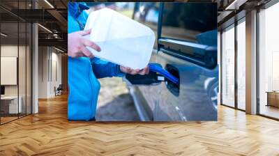 Pouring adblue to the car. Male driver adding Diesel exhaust fluid to his car. Wall mural