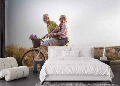 senior couple move with a bicycle together outdoor like childrens Wall mural