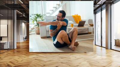 sport, fitness and healthy lifestyle concept - man making abdominal exercises at home. One mature male alone doing indoor apartment workout sport for body health care and healthy lifestyle in morning Wall mural