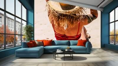 Sun and summer holiday vacation concept with people at the beach and caucasian woman viewed from back with tourist hat enjoying the day and the outdoor relax leisure activity Wall mural