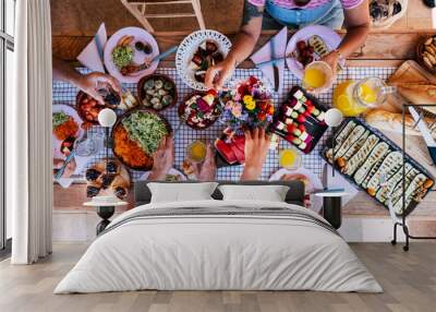 Top view of group of friends have fun together in an healthy fresh seasonal brunch together - coloured and energetic food to eat with friends or family - people stay ogether at home or restaurant Wall mural