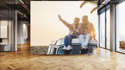 Travel and enjoying life lifestyle in love for couple in relationship sitting on the roof of a old vintage romantic van with sunset and sunlight golden tones background - forever together wanderlust  Wall mural