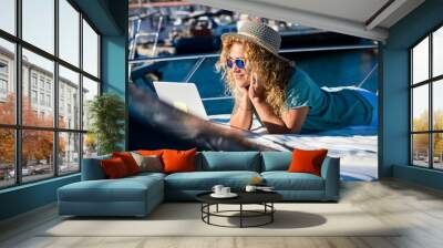 Woman smile laying on the deck of the boat in summer holiday vacation and watch laptop - concept of free lifestyle modern pretty female people - computer technology outdoor connection Wall mural