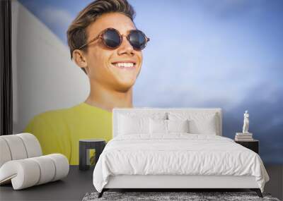 young beautiful male teenager smile outdoor with a blue sky background. summer style concept image Wall mural