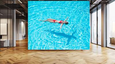 Young caucasian woman relax and enjoy summer holiday vacation floating laying on the water at the pool in hotel residence - happy adult people and tropical luxury lifestyle - red bikini Wall mural