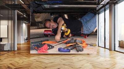 Older man working on his truck, selecting tool from pile Wall mural