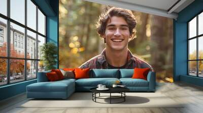 smiling young man wearing flannel shirt in a forest Wall mural