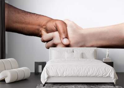 African man and Caucasian woman shake hands, studio shot, isolated Wall mural