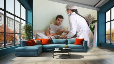  nurse at home looks at the boy's throat, the boy is sick, a doctor in a mask comes to a home call, viral serious disease, treatment, child, baby, kid, covid, lockdown, disease, virus Wall mural