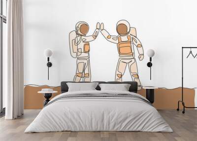 One single line drawing of two young happy astronauts gave high five while meeting on the street in moon surface vector illustration. Cosmonaut outer space concept. Modern continuous line draw design Wall mural