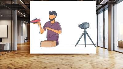 Single one line drawing Arabian male blogger makes video review on camera on topic of sneakers. Online shopping, social media and influencer concept. Continuous line draw design vector illustration Wall mural