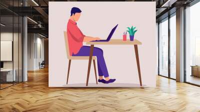 Side View Of A Young Man Working At A Desk With Laptop. Wall mural