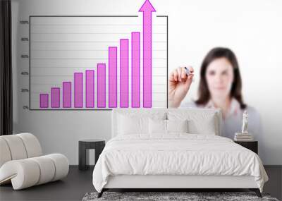 Young business woman writing over achievement bar chart, white background.  Wall mural