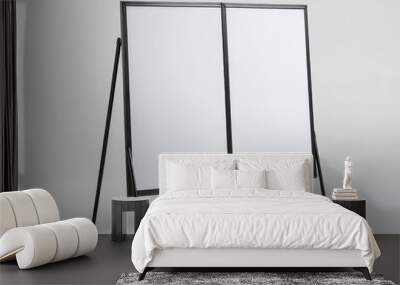 2408 139.A minimalist foldable poster stand with two empty sides, each large and rectangular, framed in thin metallic borders. The stand is set against a white background, its light structure and Wall mural