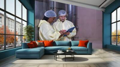 Technicians staff woman and man caucasian two person smiling talk and inspect check quality control working job in wine vats barrels on modern technology winemaking factory industry plant warehouse. Wall mural