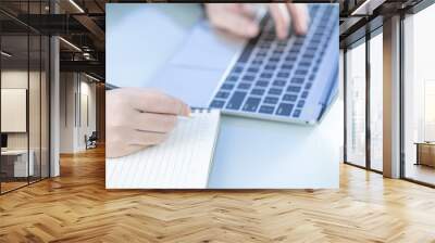 Woman working at home office using laptop searching web, browsing information Wall mural