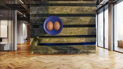 Two fresh eggs of farm in a beautiful blue bowl with pattern. Wall mural