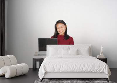 Young Asian woman Showing blank screen laptop wearing red t-shirt isolated on white background Wall mural