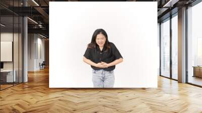 Young Asian woman suffering stomachache wearing Black t-shirt and jeans isolated on white background Wall mural