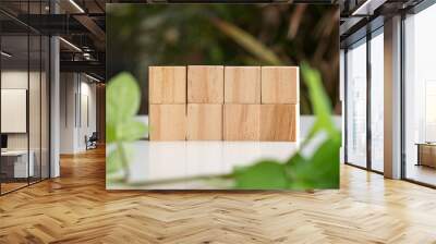 Eight blank wooden block cubes in two rows. On nature and green leaf background. Free text and template. Wall mural