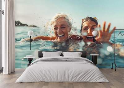 Two senior women swimming and having summer fun in the sea Wall mural