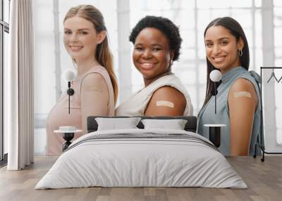 Businesswoman with plaster after vaccination for business covid vaccine, safety and health protocol, protection against the virus. Smiling faces of female coworker standing together, showing support Wall mural