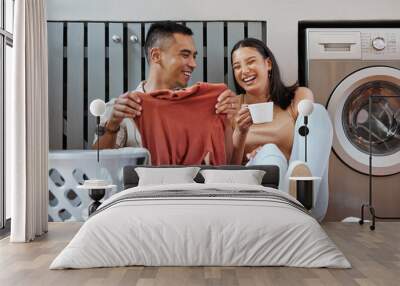 Carefree and funny couple doing laundry and relaxing together at home in the morning. Silly, goofy and playful lovers laughing and giggling while cleaning the washing, and doing house chores Wall mural