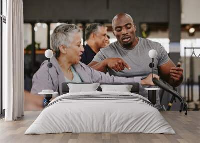 Elderly group, exercise bike and personal trainer for fitness, timer and retirement wellness by blurred background. Senior woman, bicycle training and diversity with black man, progress and coaching Wall mural