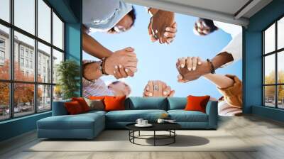 Diversity, support and people holding hands in trust and unity for community against sky background. Hand of diverse group in solidarity for united team building collaboration and teamwork success Wall mural