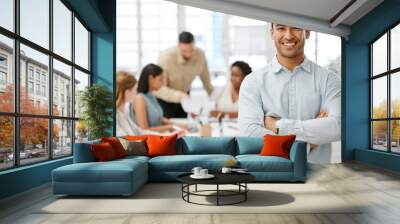 Smiling, happy and proud young business man with arms crossed showing great leadership to his team in an office. Portrait of a confident entrepreneur satisfied with new opportunity in a startup Wall mural