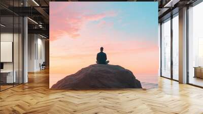 Back view of a person meditating on a large rock overlooking a serene ocean at sunset symbolizing stress relief and inner peace through mindfulness and nature Wall mural