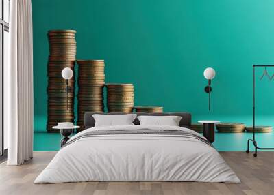 Stacks of golden coins decreasing in height on a turquoise background symbolizing financial loss and economic decline Wall mural