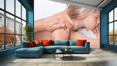 A teenage girl with white hair is lying on her stomach. A professional doctor does a back massage. Close-up. Wall mural