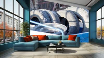 small trailer, blue color. it contains a lot of old tires and wheels. concept change tires on the car. Wall mural