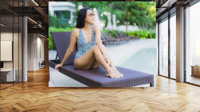 Beautiful young asian women happy smile relax around outdoor swimming pool in hotel resort for travel in holiday vacation Wall mural